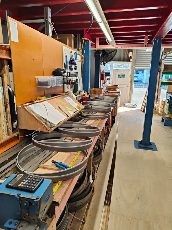 Bandsaw blade measuring and preparation bench showing coiled welded blades, measuring systems and production workflow at United Products NZ